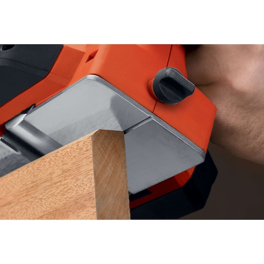 BLACKDECKER 7698K power planer smoothing wood edge, close-up view of base plate and adjustment knob.