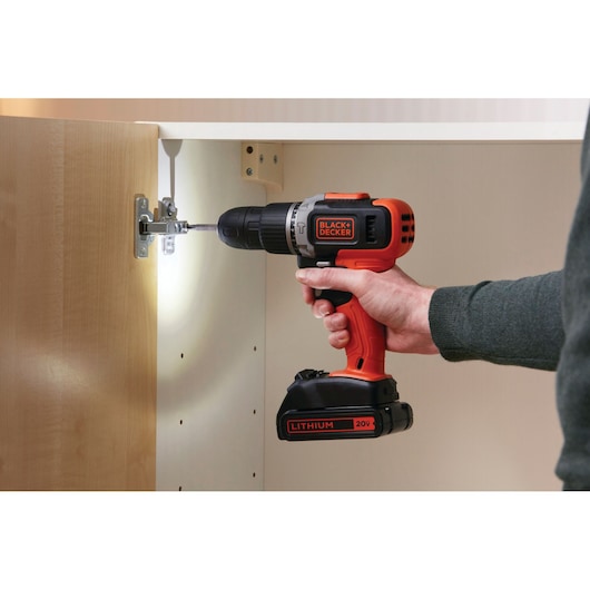 BLACKDECKER BCK21S1S cordless drill, orange and black, used for cabinet assembly, side angle.