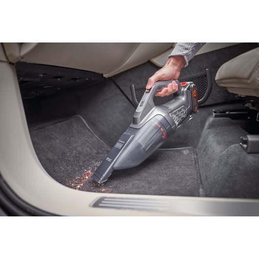 Photo of BLACKDECKER BCHV001D1 handheld vacuum cleaner being used to clean car floor mat.