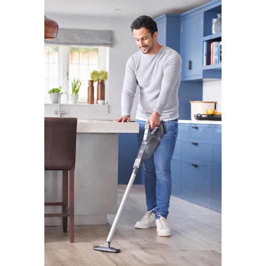 BLACKDECKER BCHV001D1 cordless stick vacuum used for cleaning kitchen floor.