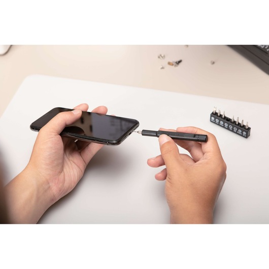 BLACKDECKER BD40K27 precision screwdriver set used to open a smartphone, photography at desktop angle.