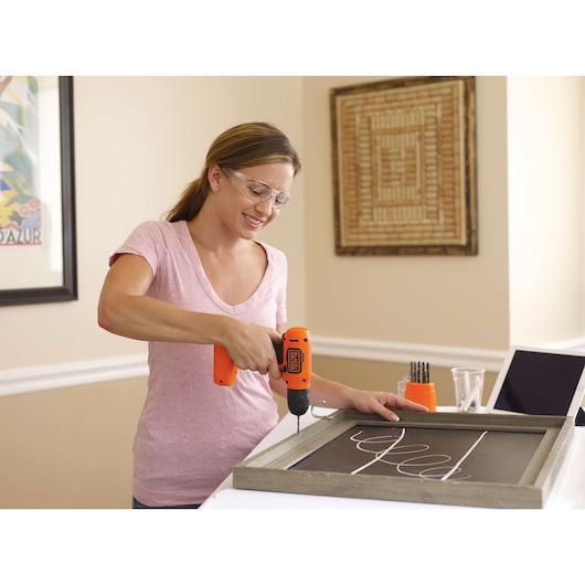 Photo of BLACKDECKER BDCD8C cordless drill used to assemble a wooden frame indoors, additional drill bits visible.
