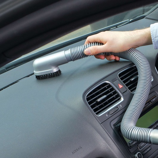 BLACKDECKER BDCV610-LA vacuum hose with brush cleaning a car dashboard, close-up angle.