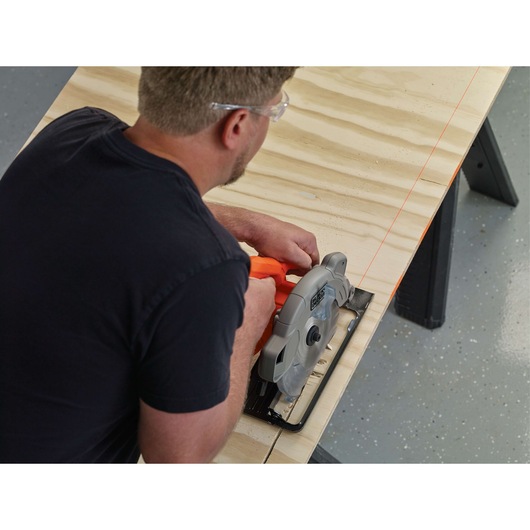 Photo of BLACKDECKER BDECS300C circular saw cutting plywood on workbench in workshop.