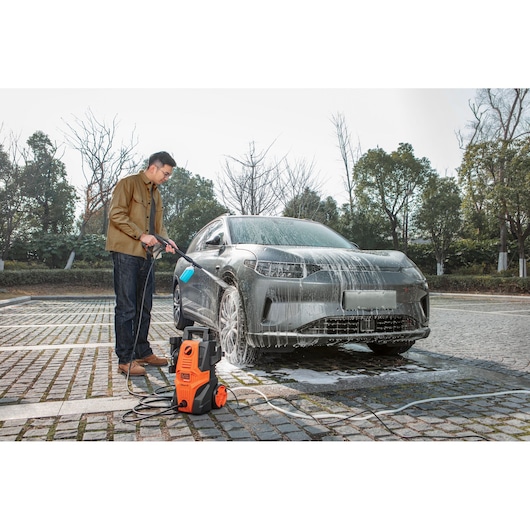 BLACKDECKER BEPWB1740 pressure washer cleaning a car outdoors with foam, product in foreground.