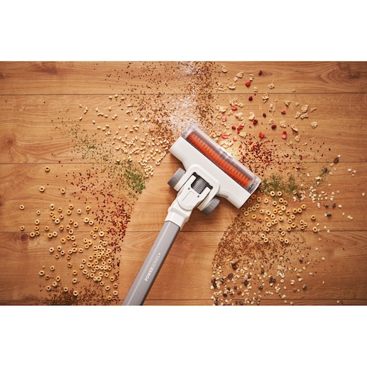BLACKDECKER BHFEA520J stick vacuum cleaning cereal and crumbs on a wooden floor, top view.
