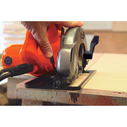 BLACKDECKER CS1004 circular saw cutting plywood, close-up of handle and blade in use.