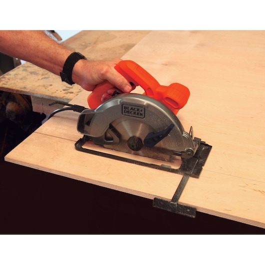 BLACKDECKER CS1004 circular saw cutting wood board, close-up of tool in use.