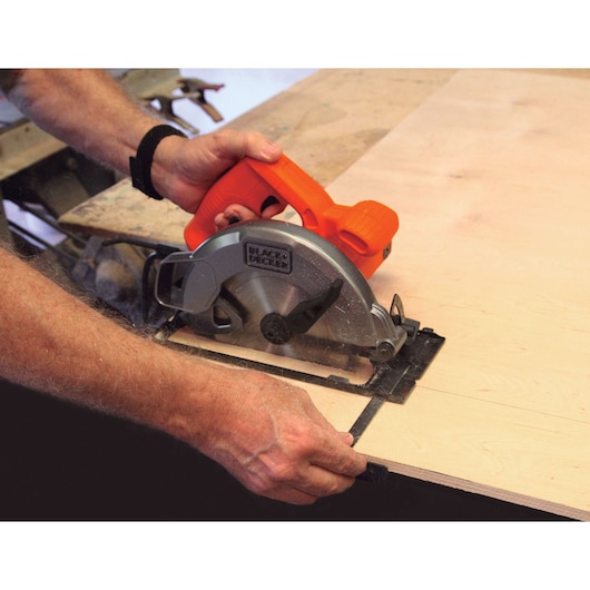 BLACKDECKER CS1004 circular saw cutting plywood, close-up of tool in use on workbench.