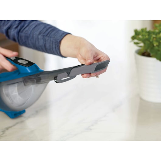 BLACKDECKER HLVA320J26 handheld vacuum being used with a crevice tool attachment on a countertop.