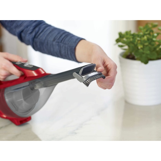 Photo of BLACKDECKER HLVA320J26 handheld vacuum with extendable brush attachment, used on a countertop.