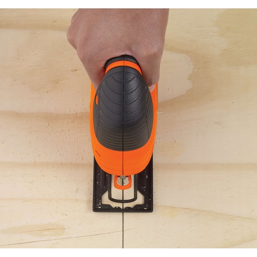 Photo of BLACKDECKER KS701PEK jigsaw cutting a straight line in wood, top view close-up.