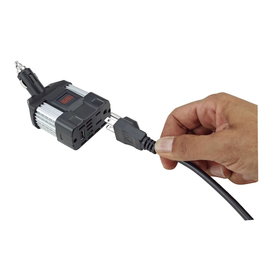 BLACKDECKER PI100LA power inverter, hand plugging cable, front angle, black and silver device.